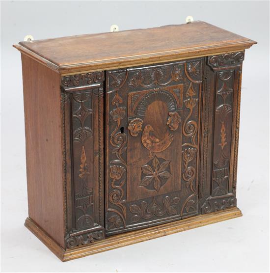 A 19th century Swiss carved walnut wall cupboard, W.2ft D.10in. H.1ft 10in.